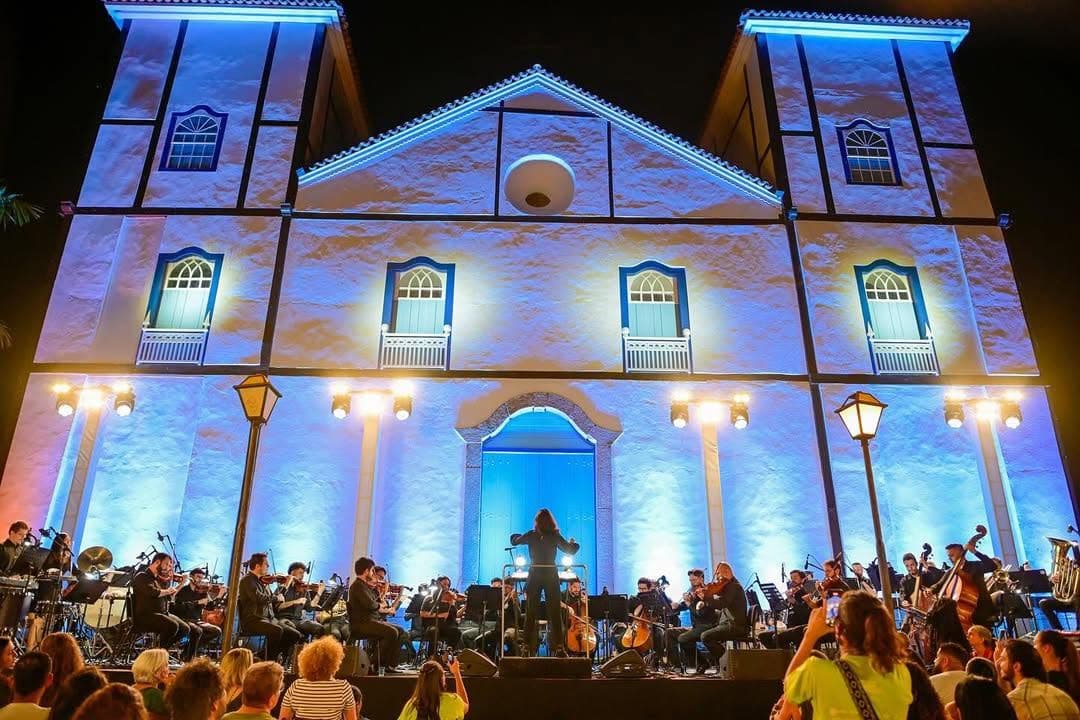 Igreja Matriz de Pirenópolis iluminada em azul durante apresentação de orquestra no Canto da Primavera