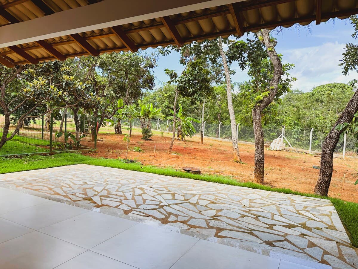 Varanda coberta da Casa Mato Verde, com piso de pedra e o cerrado ao fundo